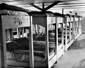 Das schwarzweiß Foto zeigt den Blick in die Unterkunft eines Arbeiterlagers.