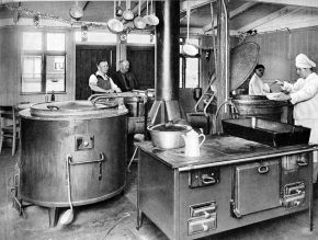 Das schwarzweiß Foto zeigt die Küche in einem Arbeiterlager.
