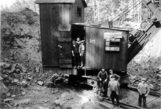 Auf dem schwarzweiß Foto sieht man die Besatzung des Dampfbaggers der ARGE Schmitt und Fey.